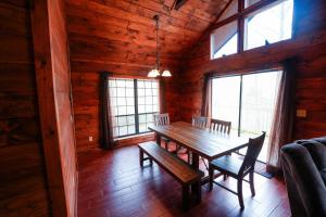 a dining room with a wooden table and chairs at The Bearfoot Cabin! Ideally located, decorated for Christmas, Fireplace, Game Room! in Sevierville