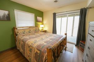 a bedroom with a bed with green walls and a window at The Bearfoot Cabin! Ideally located, decorated for Christmas, Fireplace, Game Room! in Sevierville