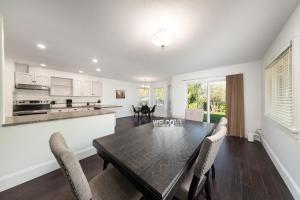 eine Küche und ein Esszimmer mit einem Holztisch und Stühlen in der Unterkunft The Langley Courtyard Home 2BR, 2BA for 6 Guests in Langley