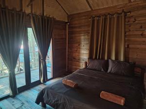 a bedroom with a bed with curtains and a window at Nirvana Archipel Resort in Vang Vieng