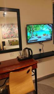 Una habitación con una mesa con espejo y un televisor. en Bayside & Beach Inn Langkawi, en Langkaw Island