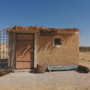 een bakstenen gebouw met een deur in de woestijn bij Arabiya House in Siwa