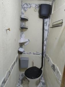 een badkamer met een toilet en een zwarte stoel bij GNOME KIT HOUSE São Tomé das Letras- Mg in São Thomé das Letras
