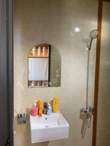 Un baño con un lavabo blanco y un espejo. en NATURE HOUSE l Homestay Thu Duc, en Kon Rung (1)