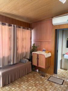 Habitación con cama y mesa con cortinas. en NATURE HOUSE l Homestay Thu Duc, en Kon Rung (1)