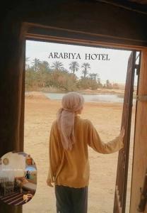 een vrouw die de deur van een hotel opent bij Arabiya House in Siwa