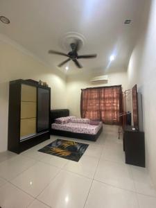 a living room with a bed and a ceiling fan at Azizan Homestay Bahau in Bahau +5 photos