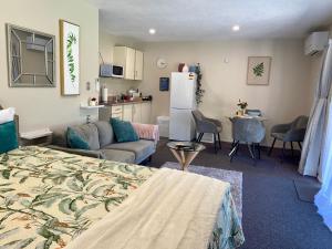 a living room with a bed and a kitchen at Heritage Park Lodge in Haast