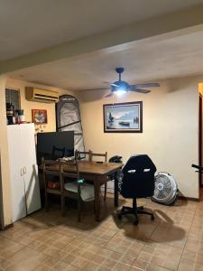 a dining room with a table and a ceiling fan at Surf House Aparment in Coco