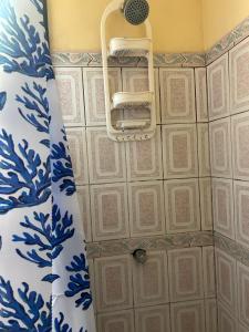 a shower in a bathroom with blue and white tiles at Surf House Aparment in Coco +3 photos
