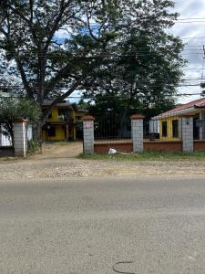 a street with a yellow house and a tree at Surf House Aparment in Coco