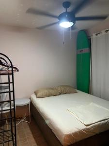 a room with a bed with a surfboard on the wall at Surf House Aparment in Coco