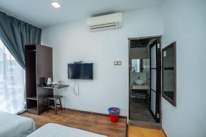 a hotel room with a mirror and a tv at De Grand Boutique Hotel in Sepang