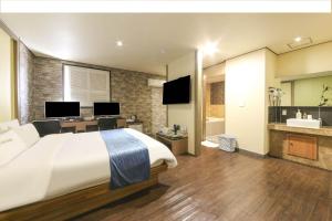 a hotel room with a large bed and a bathroom at Chakan Hotel in Gunsan