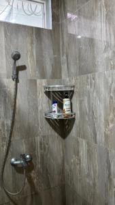 a shower in a bathroom with a shower head at Kalyana Guest House in Bandung +7 photos