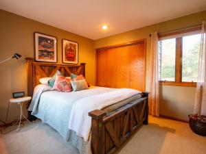 Country Stay 6 Min to Town with Deck & Jetted Tub في لورانس: غرفة نوم مع سرير مع اللوح الأمامي الخشبي