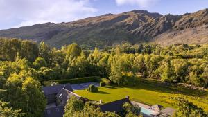 an aerial view of a house with a large lawn and mountains at Wharenui Holiday Home by MajorDomo in Arrowtown