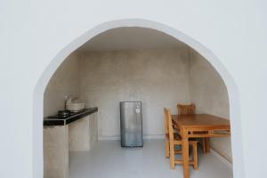 una cocina con una mesa y un refrigerador en Dragonfly, en Nusa Penida