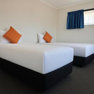 Dos camas en una habitación de hotel con en Pure Motel, en Rotorua
