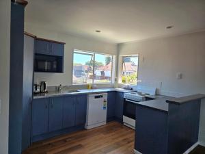 een keuken met blauwe kasten en een aanrecht bij Pure Motel in Rotorua