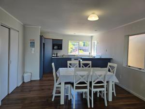 een eetkamer en keuken met een tafel en stoelen bij Pure Motel in Rotorua