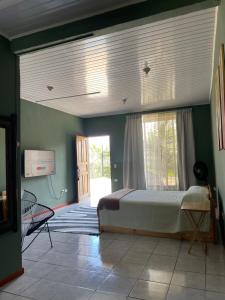 a bedroom with a bed and a large window at Big Sloth Apartment in Fortuna