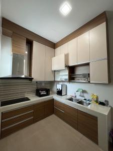 a kitchen with white cabinets and a sink and a microwave at 4 Bedroom 4 PRIVATE BATHROOM 4B12B 5 min City Center in Ipoh