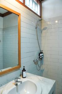 a bathroom with a sink and a mirror and a shower at Rumah Canda in Bandung +33 photos