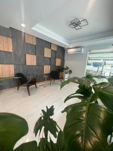 a living room with a large plant in the foreground at The Square Hotel เดอะสแควร์โฮเทลนครพนม in Nakhon Phanom