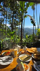 a table with plates of food and drinks on it at Mango Shadow Inn Ella in Ella +66 photos
