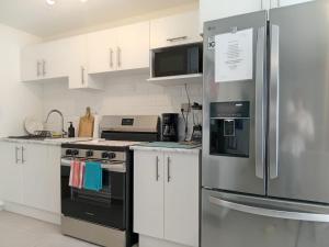 a kitchen with white cabinets and a stainless steel refrigerator at Apartamento San Andrés  +11 photos