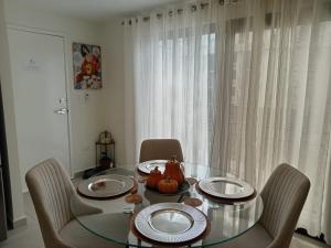 a dining room with a glass table and chairs at Apartamento San Andrés  +12 photos