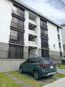 a green suv parked in front of a building at Apartamento San Andrés 