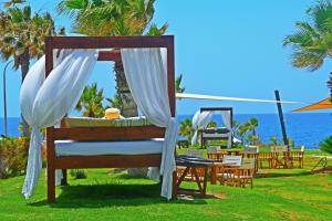 a canopy bed at a resort with a view of the ocean at Amphora Hotel & Suites in Paphos