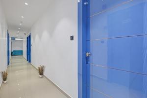 a hallway with a blue door in a building at Collection O Leo Palace in Surat