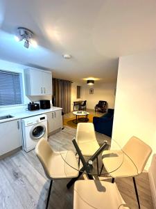 een keuken en een woonkamer met stoelen en een tafel bij Modern Ground floor 2 Bed Room Apartment Work Leisure Free Parking in Woking