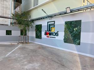 a white wall with green plants on it at The Square Hotel เดอะสแควร์โฮเทลนครพนม in Nakhon Phanom