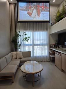 een woonkamer met een bank en een tv bij Hongdae Luxury Stay in Seoul