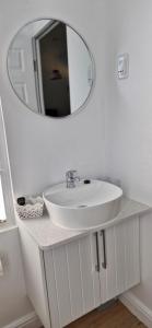 The Barracks at Brigadoon Village في بيتيس باي: حمام مع حوض أبيض ومرآة