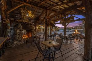 un patio con tavoli, sedie e camino in pietra di Stonegate Lodge - Pool & Firepits Room #208 a Eureka Springs