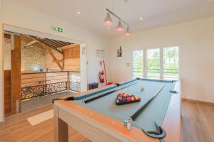 Una sala de estar con una mesa de billar. en Gîte Petit Talma détente, en Grandpré
