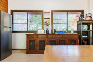 a kitchen with a stainless steel refrigerator and a table at Villa Primor madawan Koh Phangan in Wok Tum