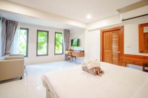 A103 Banjong 1 Bed apart, Near Nai Harn Beach في Ban Saiyuan (1): غرفة نوم بيضاء كبيرة مع سرير ومكتب +48 صورة