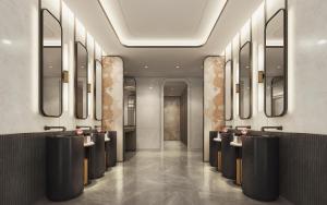un vestíbulo con una fila de lavabos y espejos en Crowne Plaza Dhaka Airport by IHG, en Dhaka