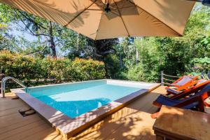 a swimming pool with an umbrella and a table and chairs at Villa Primor madawan Koh Phangan in Wok Tum