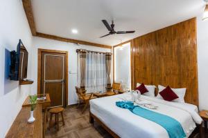 Un dormitorio con una gran cama blanca y un escritorio. en Ama Garden Sauraha, en Sauraha 23 fotos más