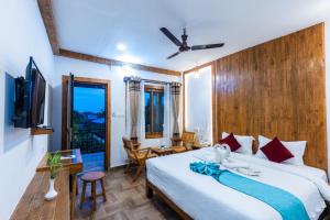 ソーラハにあるAma Garden Saurahaのベッドと机とテレビのある寝室