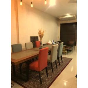 een eetkamer met een houten tafel en stoelen bij Leon Sukhumvit 62 in Bangkok