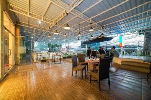 een restaurant met een tafel en stoelen en mensen die eten bij The Panorama Suites by MHM in Jakarta