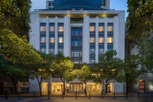 a tall white building with lights on at Mövenpick by Accor Shanghai People's Square in Shanghai